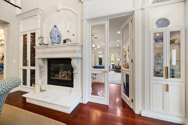 living room featuring a glass covered fireplace and dark wood-style flooring