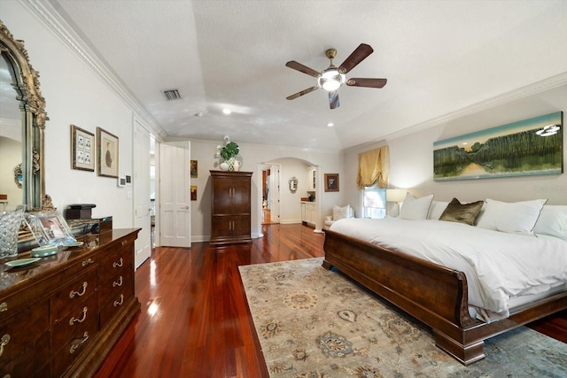 bedroom with dark wood-type flooring, arched walkways, visible vents, and ornamental molding