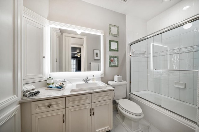 full bathroom featuring toilet, bath / shower combo with glass door, and vanity