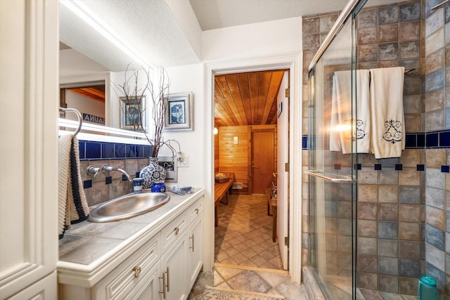 full bathroom with a stall shower, vanity, and decorative backsplash