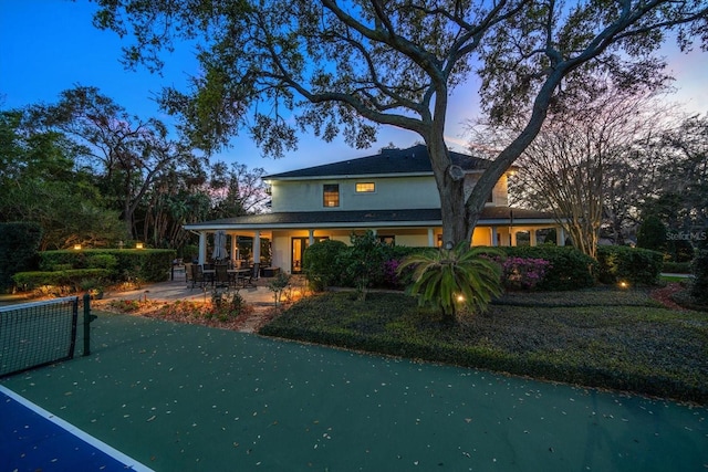 back of property at dusk with a patio and stucco siding