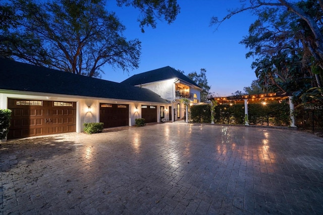 view of front of house with a garage, decorative driveway, and stucco siding