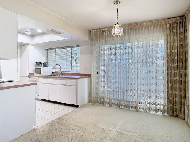 kitchen with light carpet, white appliances, a sink, visible vents, and white cabinetry