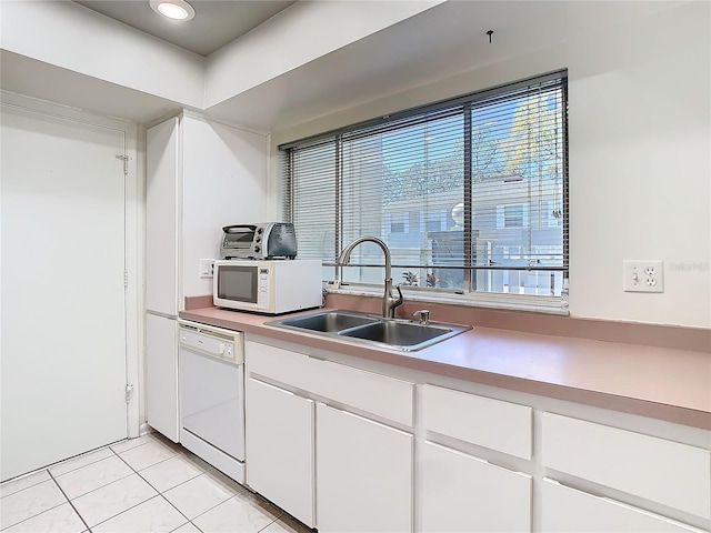 kitchen featuring light tile patterned floors, light countertops, white cabinetry, a sink, and white appliances