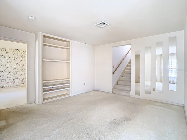 unfurnished room with stairs and visible vents