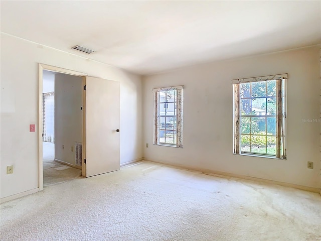 carpeted spare room featuring visible vents