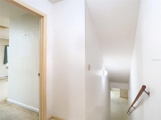 corridor with carpet flooring and an upstairs landing