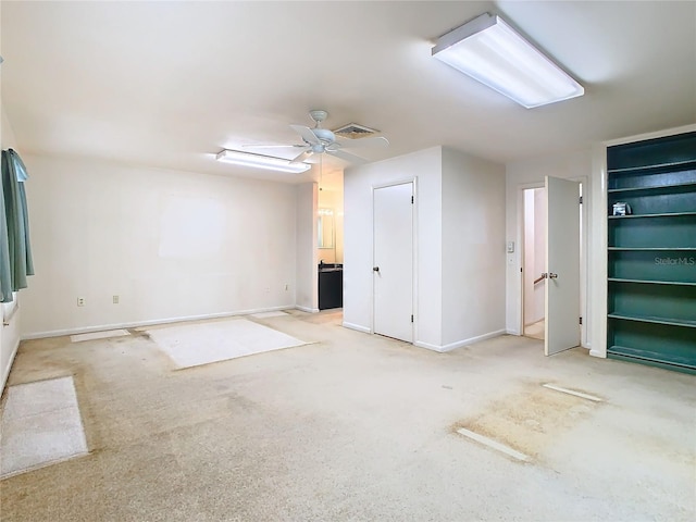 carpeted empty room featuring baseboards, visible vents, and a ceiling fan