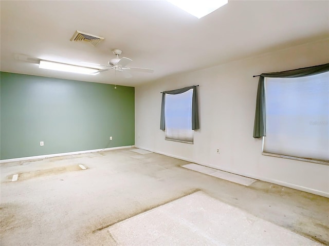 unfurnished room featuring baseboards, visible vents, and ceiling fan