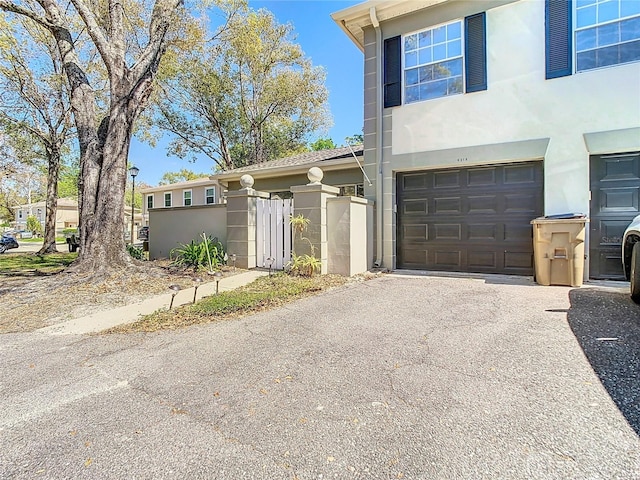 view of front of property featuring driveway, an attached garage, and stucco siding