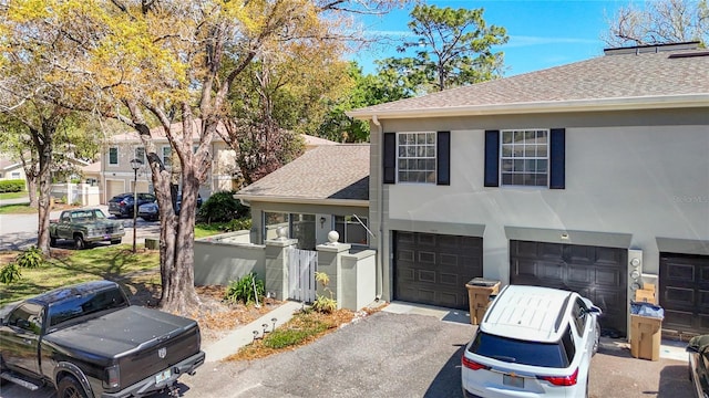 exterior space with a shingled roof, driveway, an attached garage, and stucco siding