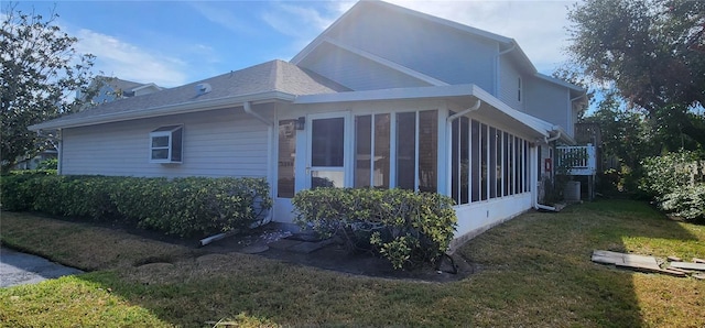 view of property exterior with a sunroom and a yard