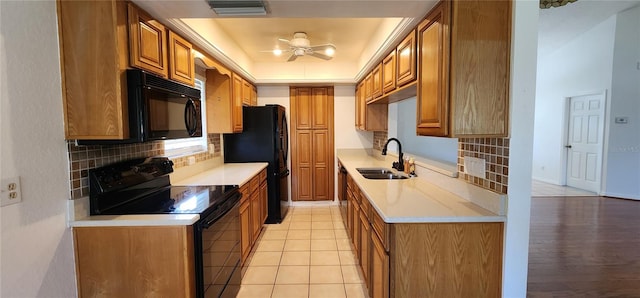 11722 Currie Ln Unit E1, Largo, FL 33774 - kitchen featuring black appliances, a sink, backsplash, brown cabinetry, and light countertops