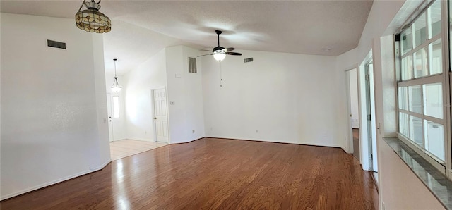 11722 Currie Ln Unit E1, Largo, FL 33774 - spare room with wood finished floors, a ceiling fan, baseboards, high vaulted ceiling, and a textured ceiling