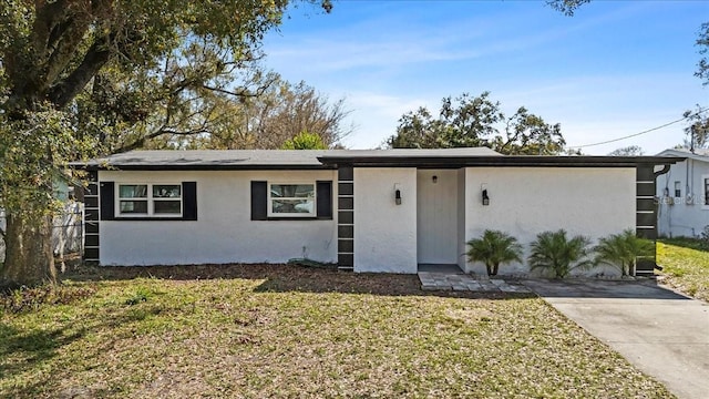 ranch-style house with a front lawn and stucco siding