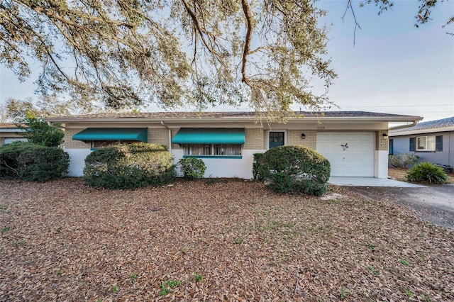 single story home featuring brick siding, driveway, and an attached garage