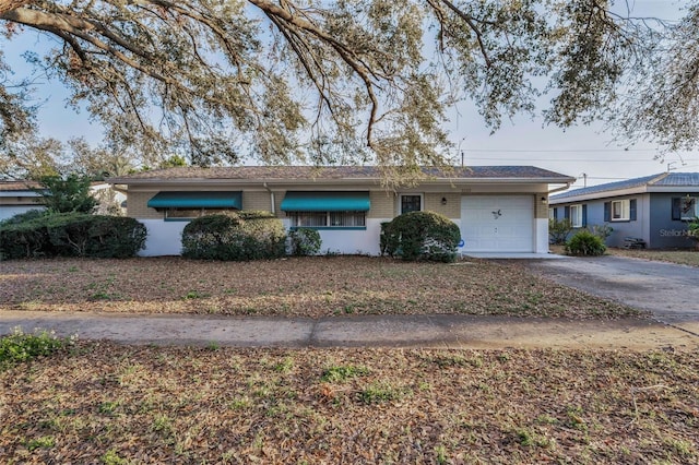 single story home with brick siding, driveway, and an attached garage