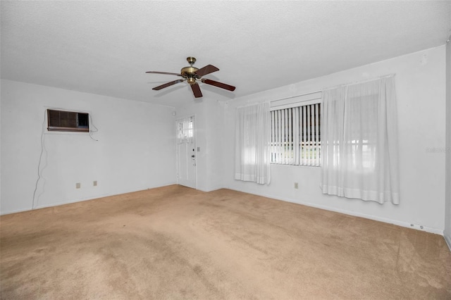 carpeted spare room featuring a ceiling fan, a wall unit AC, and a textured ceiling