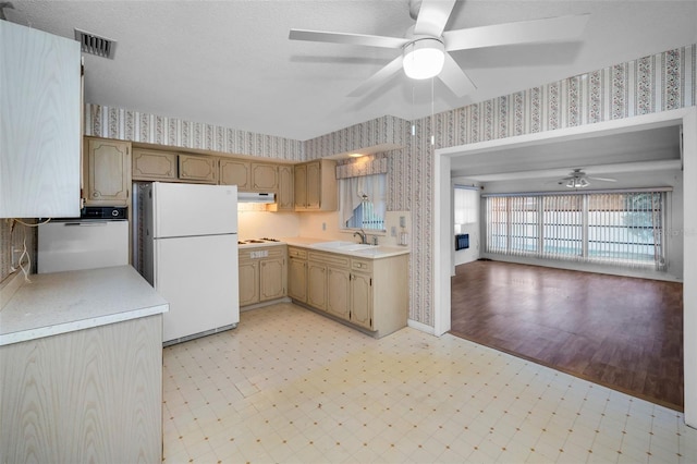 kitchen with white appliances, visible vents, light countertops, light floors, and wallpapered walls