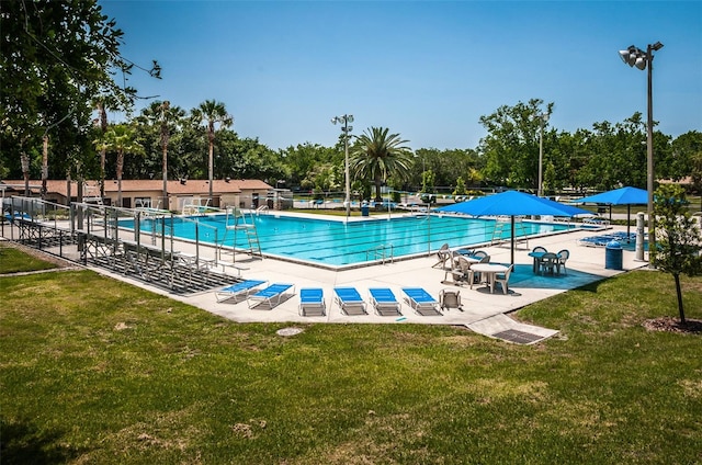 community pool featuring a yard, a patio, and fence