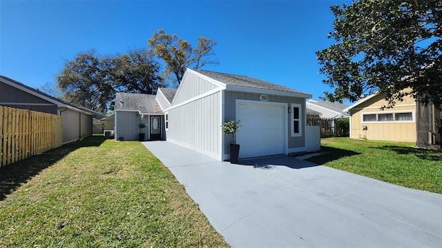 exterior space with driveway, a yard, an attached garage, and fence