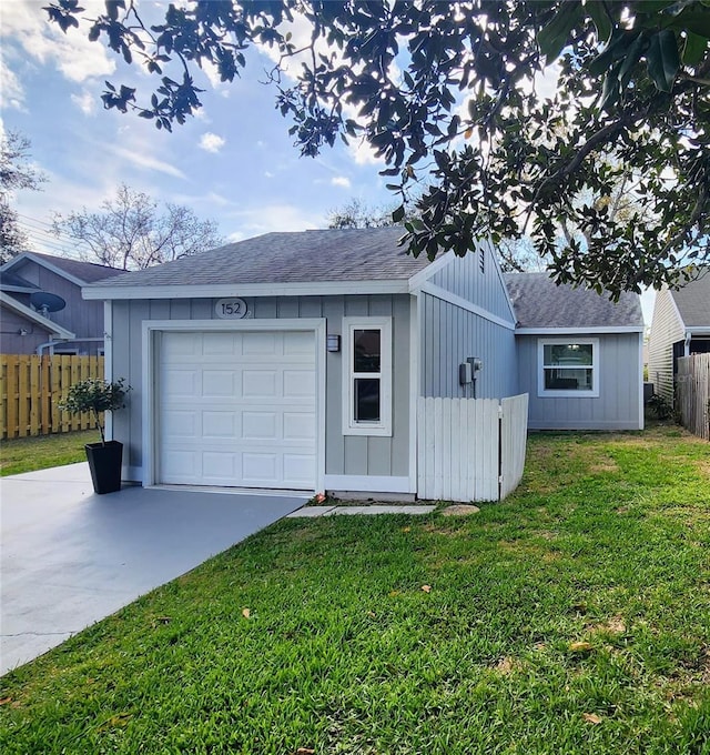 garage with fence and concrete driveway