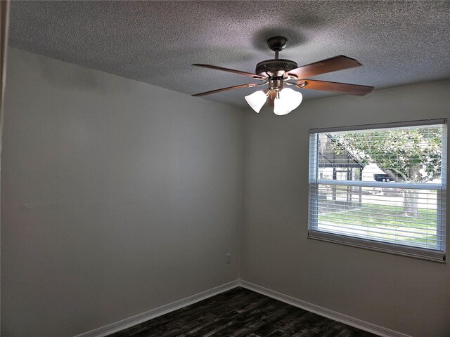 spare room with a ceiling fan, baseboards, dark wood finished floors, and a textured ceiling