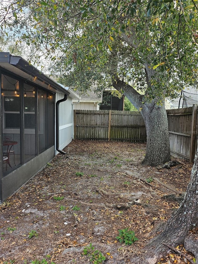 view of yard with a fenced backyard and a sunroom