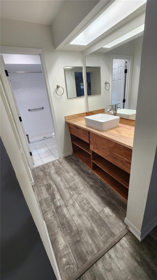 bathroom featuring wood finished floors, vanity, and baseboards