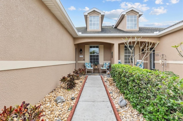 property entrance with covered porch, roof with shingles, and stucco siding