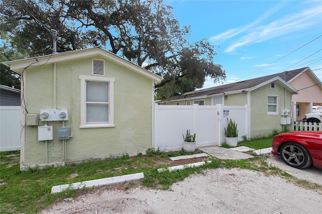 view of side of property featuring fence and stucco siding