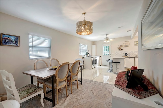 dining area featuring ceiling fan with notable chandelier and separate washer and dryer