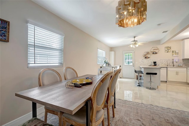 dining room with light tile patterned floors, baseboards, visible vents, and ceiling fan with notable chandelier