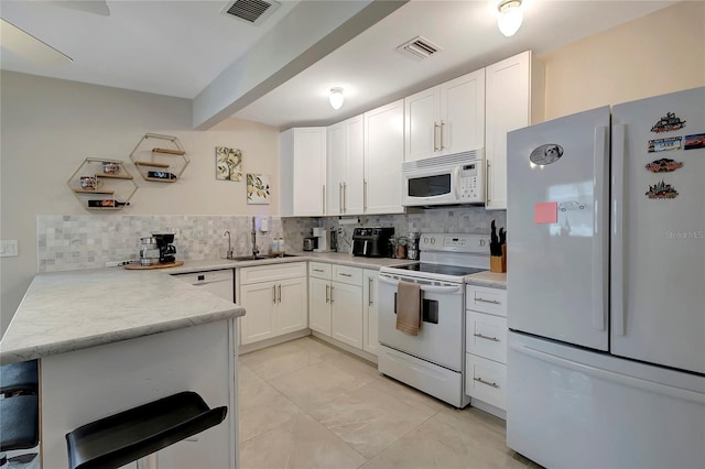 kitchen featuring light countertops, white appliances, visible vents, and white cabinets