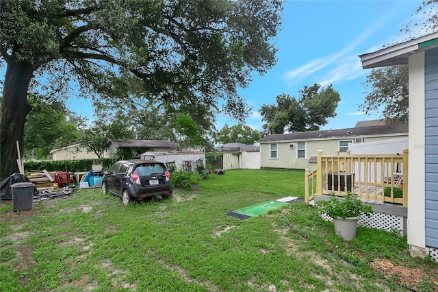 view of yard featuring fence, a deck, and central air condition unit