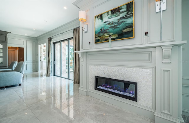 living room with crown molding, marble finish floor, a glass covered fireplace, and a decorative wall