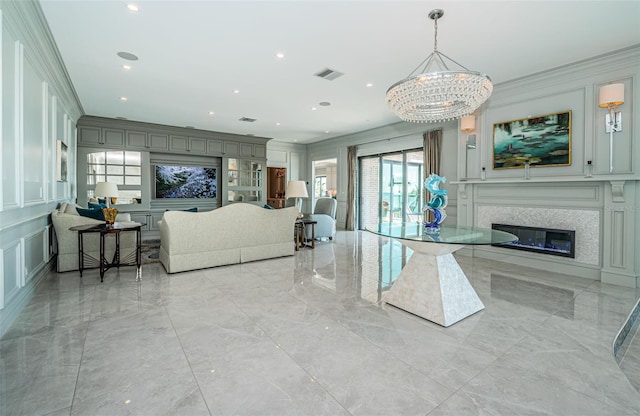 living room featuring a decorative wall, visible vents, marble finish floor, ornamental molding, and a glass covered fireplace