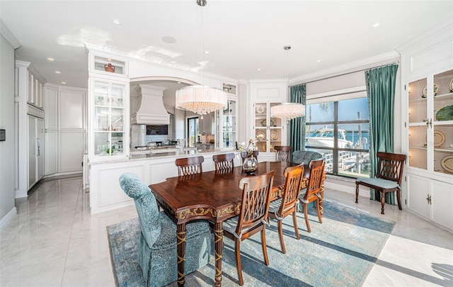 dining space featuring an inviting chandelier, a decorative wall, crown molding, and recessed lighting