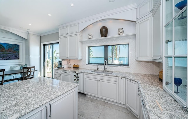 kitchen featuring crown molding, open shelves, tasteful backsplash, white cabinetry, and a sink