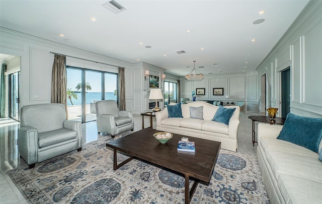 living area with crown molding, visible vents, and a decorative wall