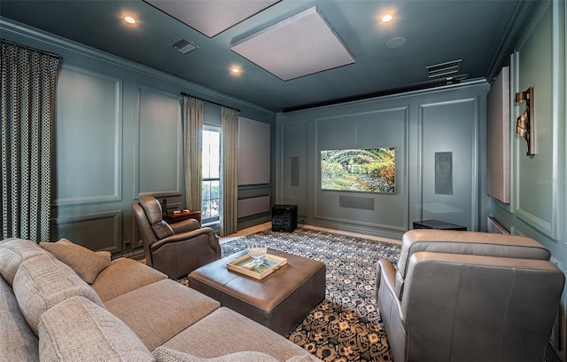 home theater with ornamental molding, visible vents, and a decorative wall