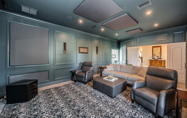 cinema room with ornamental molding, visible vents, and a decorative wall