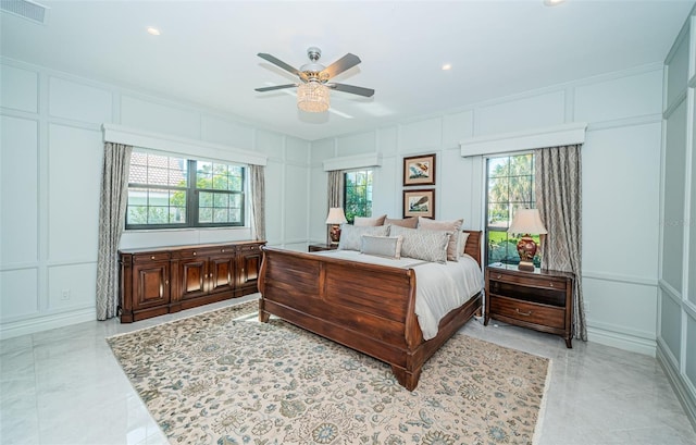 bedroom featuring ceiling fan, recessed lighting, visible vents, and a decorative wall