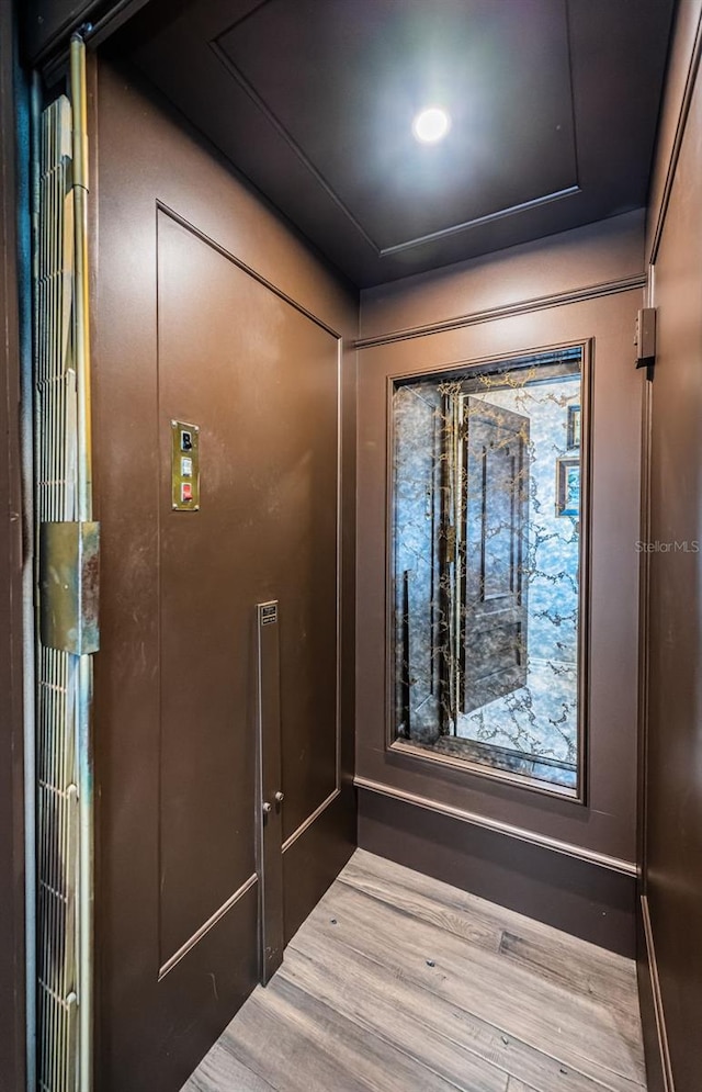 details featuring elevator and wood finished floors