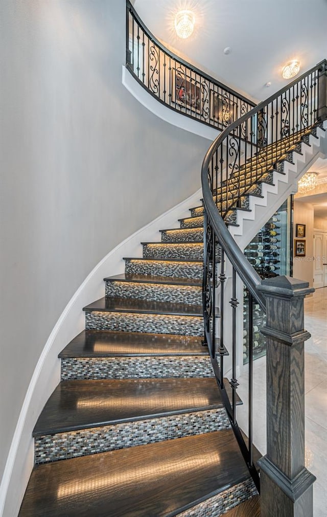 stairs with a towering ceiling and baseboards