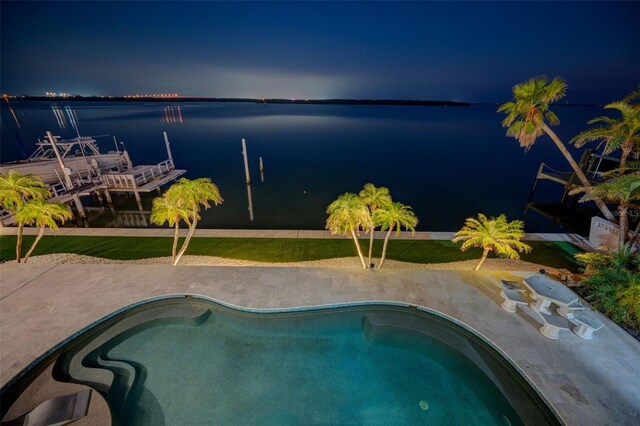 outdoor pool with a patio and a water view