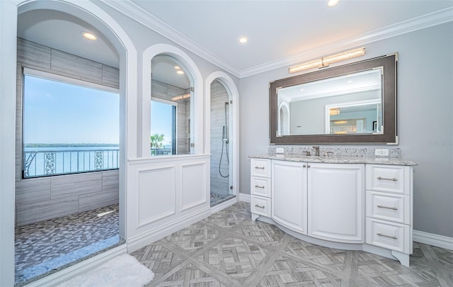 full bath featuring recessed lighting, vanity, baseboards, a tile shower, and crown molding