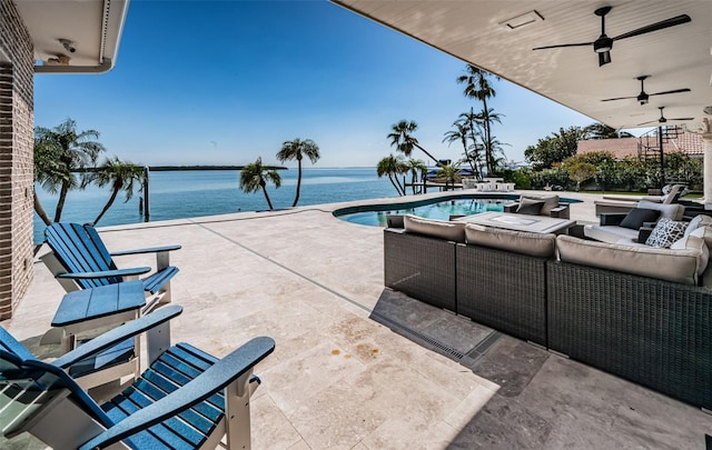 view of patio featuring a water view, an outdoor pool, an outdoor living space, and a ceiling fan