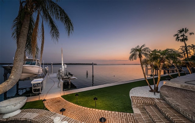 dock area with a water view, a yard, and boat lift