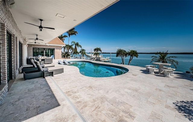 pool with a water view, outdoor lounge area, a ceiling fan, and a patio